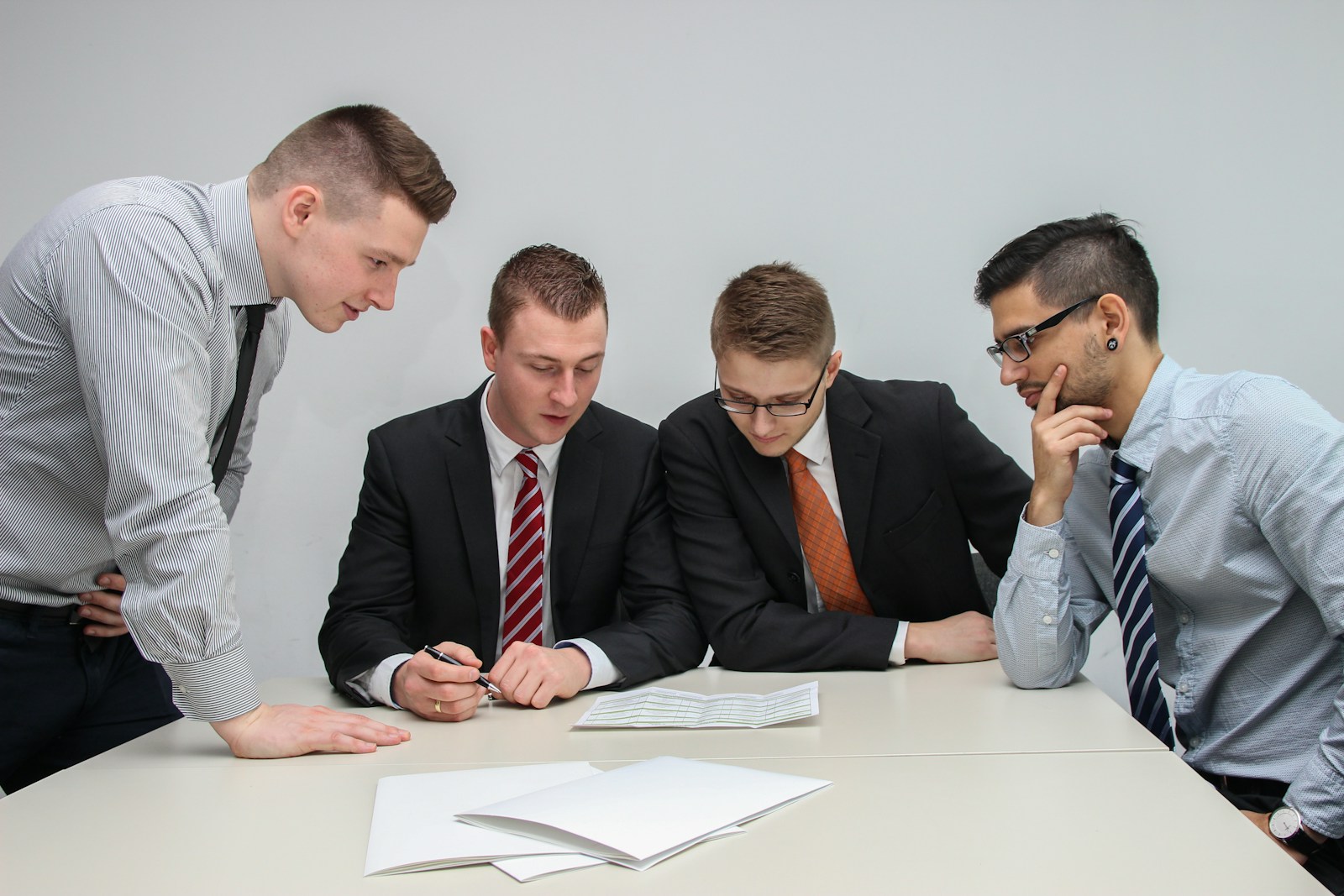 Four people looking at a paper on a table