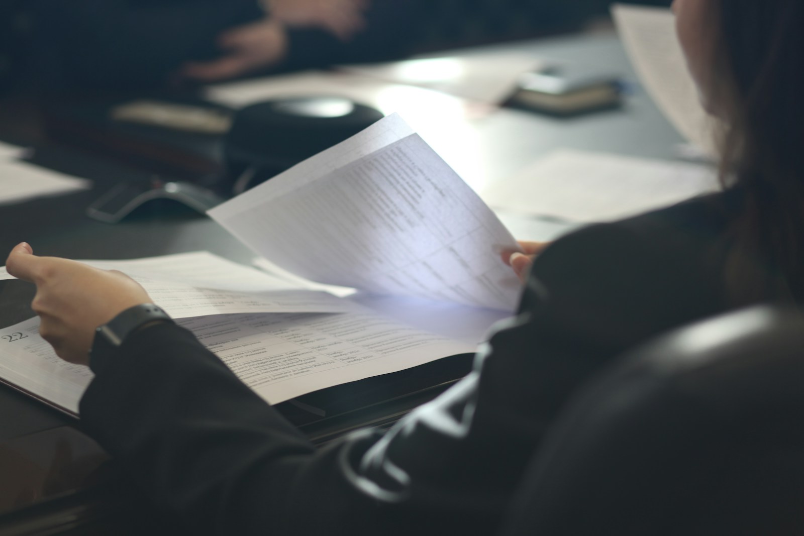 Woman reading a paper at a table
