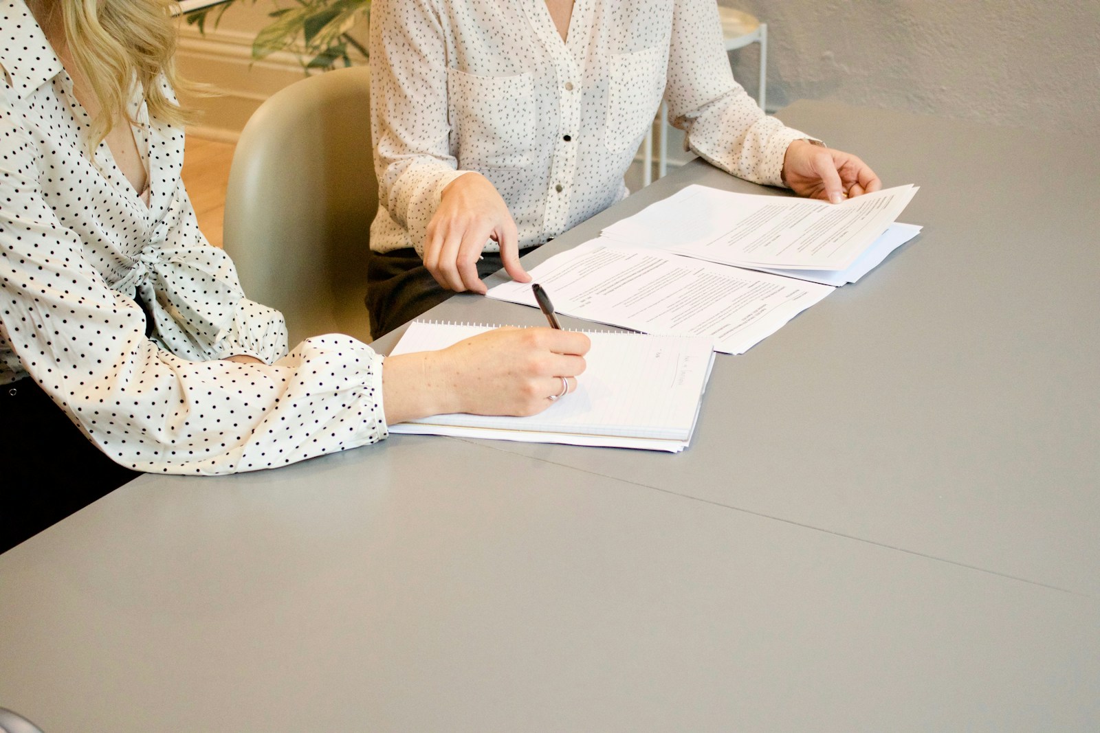Woman signing papers beside a colleague